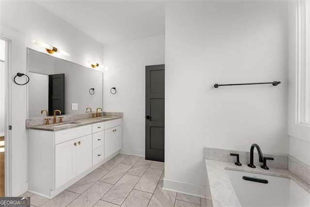 bathroom featuring double vanity, baseboards, a bathtub, and a sink