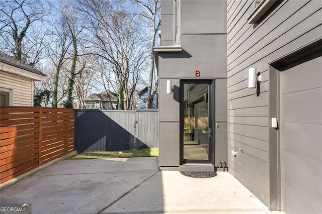 doorway to property featuring a patio and fence