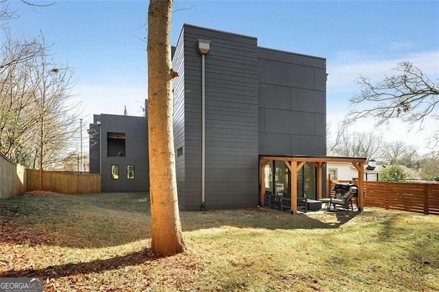 rear view of house with a fenced backyard, a patio, and a yard