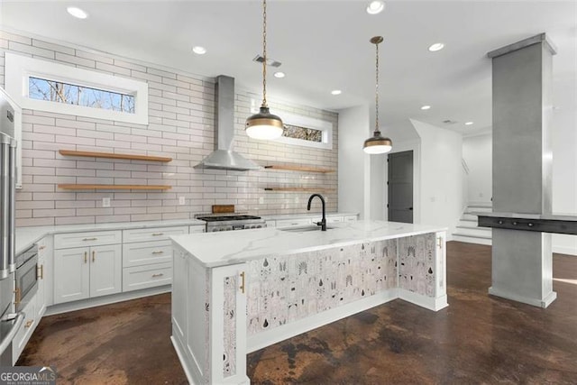 kitchen featuring a sink, white cabinetry, wall chimney range hood, open shelves, and decorative light fixtures