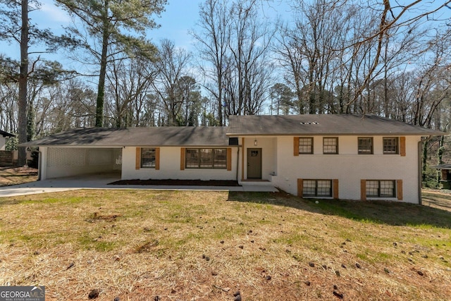 view of front of home featuring an attached carport, concrete driveway, brick siding, and a front yard