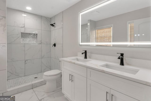 full bath featuring a marble finish shower, marble finish floor, toilet, and a sink