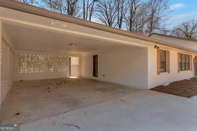 exterior space featuring an attached carport, concrete driveway, and brick siding