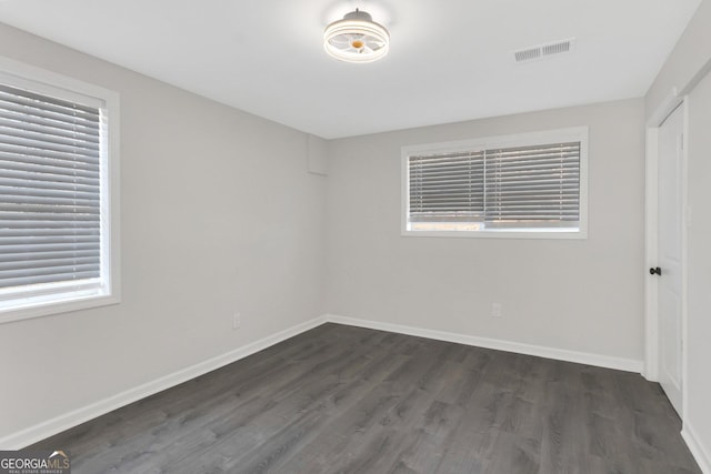 unfurnished bedroom with dark wood finished floors, visible vents, and baseboards