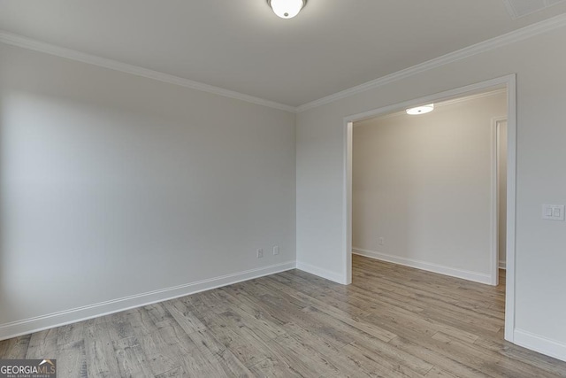 empty room featuring light wood-type flooring and crown molding