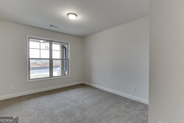 carpeted empty room featuring baseboards and visible vents