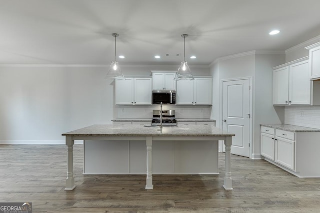 kitchen featuring an island with sink, appliances with stainless steel finishes, light stone counters, and hanging light fixtures