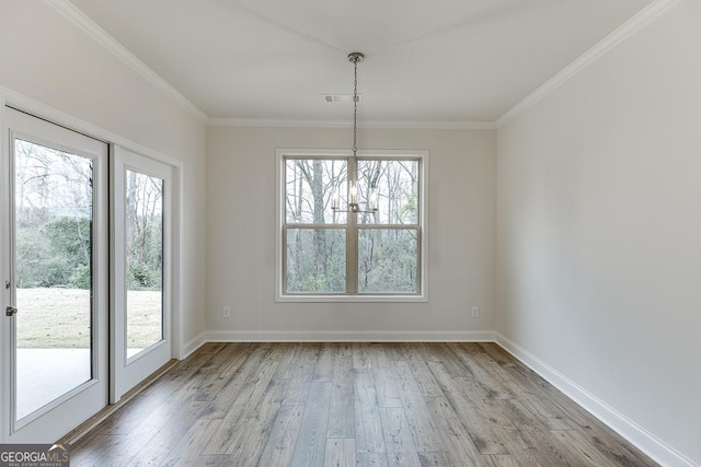 unfurnished dining area with light wood-style floors, ornamental molding, and baseboards