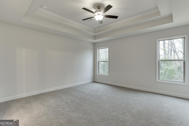 unfurnished room with carpet, a raised ceiling, visible vents, and baseboards