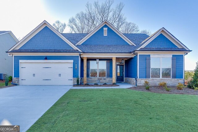 craftsman inspired home with a garage, stone siding, concrete driveway, roof with shingles, and a front yard