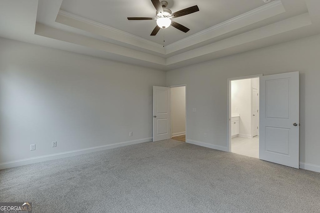 unfurnished bedroom with a tray ceiling and crown molding