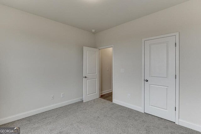 unfurnished bedroom featuring carpet floors and baseboards