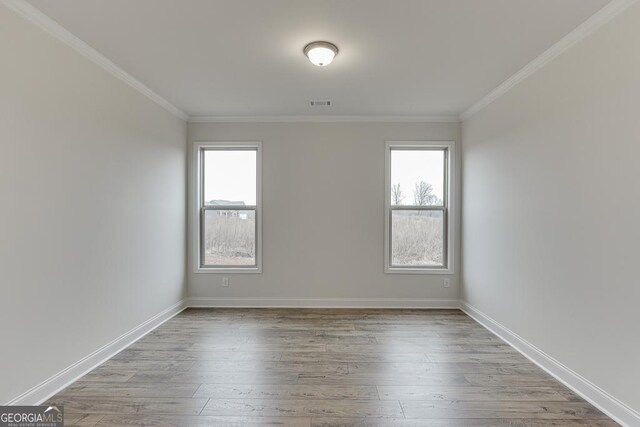 unfurnished room with ornamental molding, light wood-style floors, and a healthy amount of sunlight