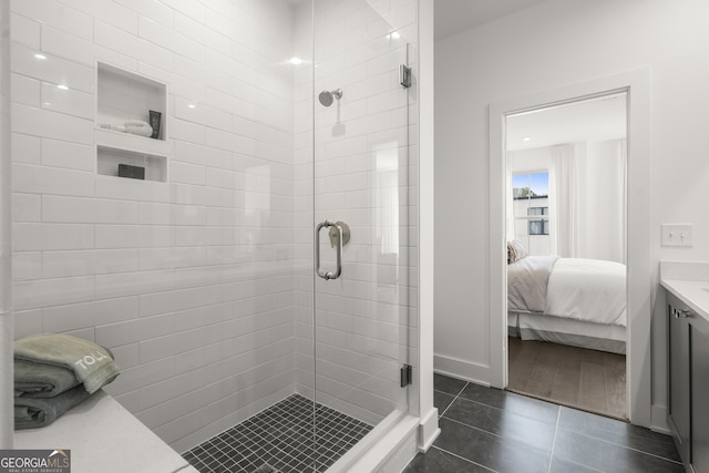 full bathroom featuring tile patterned floors, a shower stall, vanity, and ensuite bathroom