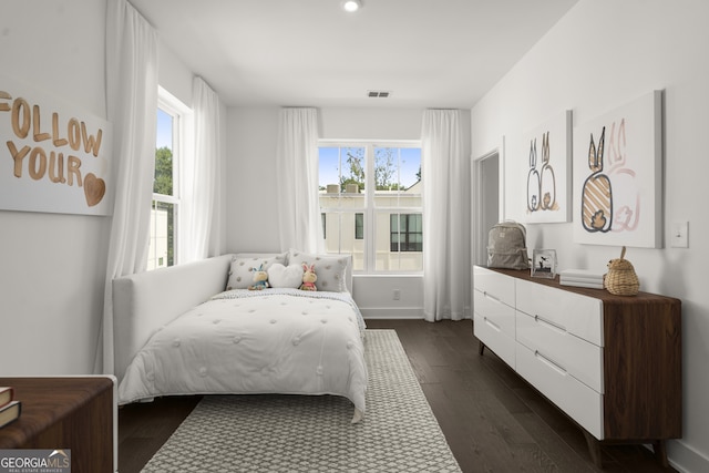 bedroom with baseboards, multiple windows, visible vents, and dark wood-style flooring