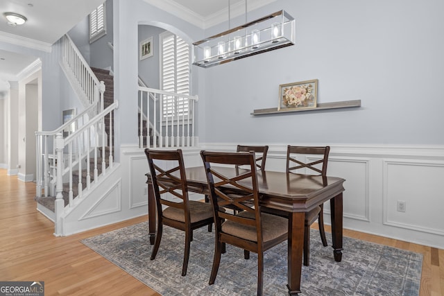 dining space featuring visible vents, stairs, ornamental molding, and wood finished floors