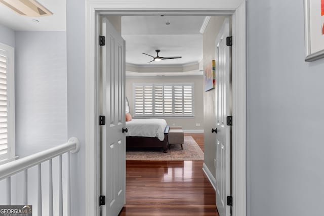 hall with dark wood-style floors, baseboards, and ornamental molding