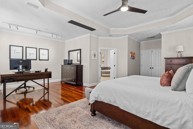 bedroom featuring dark wood-style floors, a tray ceiling, crown molding, visible vents, and baseboards