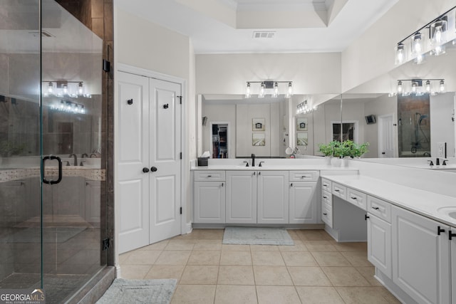 bathroom with double vanity, a stall shower, tile patterned flooring, and a sink