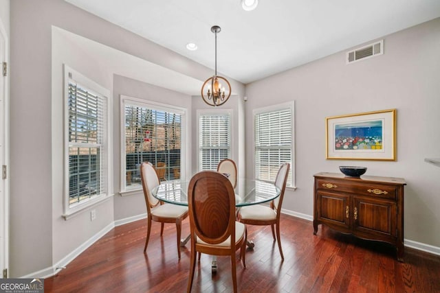 dining area featuring baseboards, dark wood-style flooring, visible vents, and an inviting chandelier