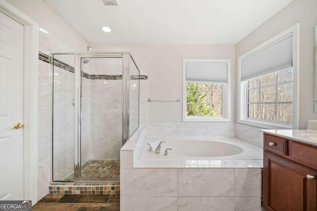 full bathroom with recessed lighting, a garden tub, vanity, and a shower stall