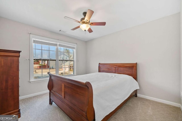 bedroom with light carpet, ceiling fan, visible vents, and baseboards