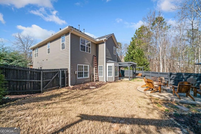 back of property with an outdoor fire pit, a patio area, a fenced backyard, and a yard