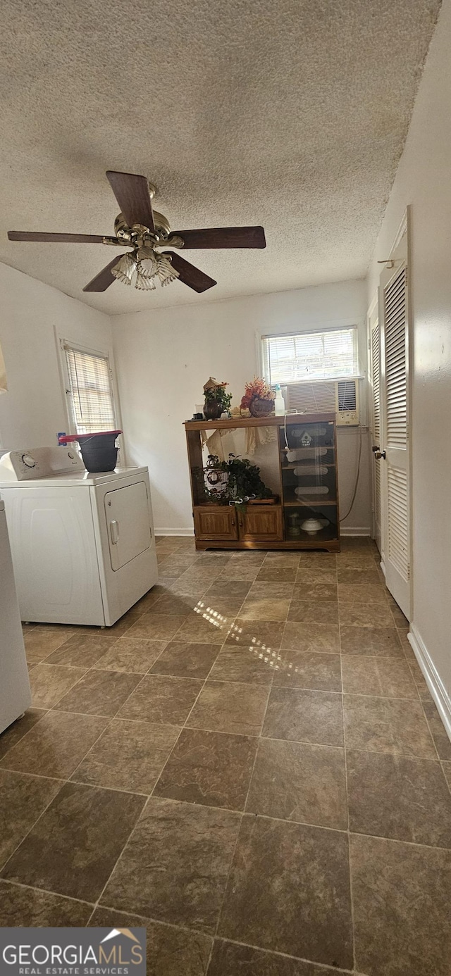 laundry room with washer and dryer, laundry area, a textured ceiling, and baseboards