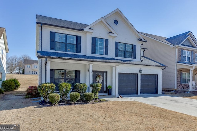 traditional-style home featuring a garage, covered porch, a shingled roof, and concrete driveway