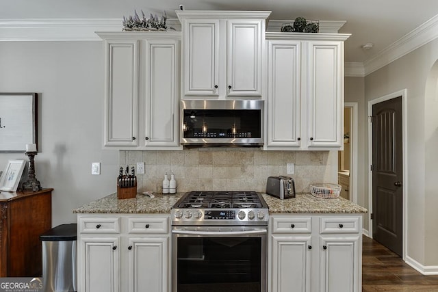 kitchen featuring ornamental molding, appliances with stainless steel finishes, light stone countertops, and white cabinets