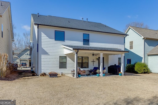 rear view of property featuring a ceiling fan and a patio area