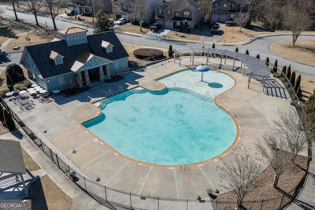 community pool with a patio and fence