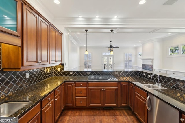 kitchen with appliances with stainless steel finishes, dark wood-type flooring, a sink, and decorative backsplash