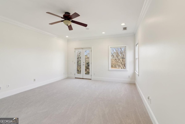 unfurnished room with light carpet, visible vents, baseboards, french doors, and crown molding