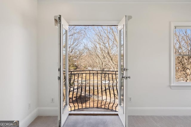 doorway featuring carpet and baseboards