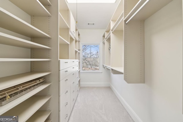 walk in closet featuring visible vents and light colored carpet