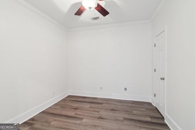 empty room featuring ornamental molding, visible vents, baseboards, and wood finished floors