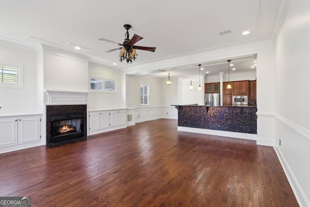 unfurnished living room featuring ceiling fan, dark wood-type flooring, a fireplace with flush hearth, and a wealth of natural light