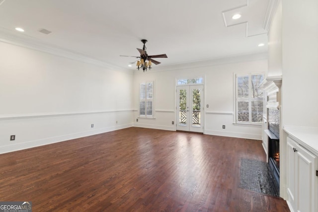 unfurnished living room with french doors, crown molding, a fireplace with flush hearth, wood finished floors, and baseboards