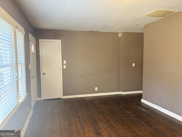 unfurnished room featuring visible vents, baseboards, and wood finished floors