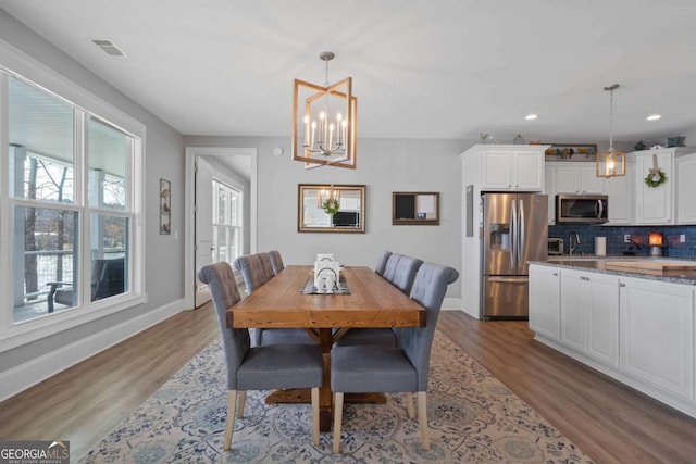 dining space with visible vents, baseboards, light wood-style flooring, a chandelier, and recessed lighting