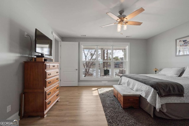 bedroom with ceiling fan, baseboards, and wood finished floors