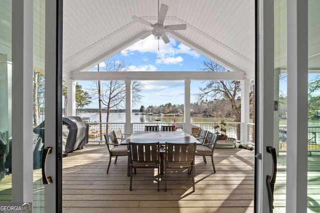 sunroom / solarium with a water view, ceiling fan, and vaulted ceiling