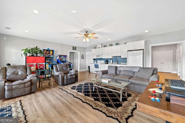 living area featuring baseboards, visible vents, a ceiling fan, light wood-style flooring, and recessed lighting