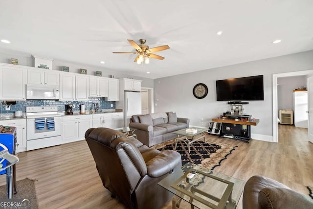 living area featuring light wood-style floors, ceiling fan, baseboards, and recessed lighting