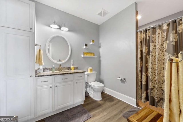 full bathroom with baseboards, visible vents, toilet, wood finished floors, and vanity