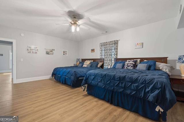 bedroom with baseboards, ceiling fan, visible vents, and light wood finished floors