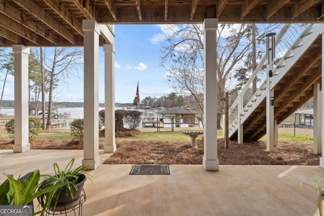 view of patio / terrace featuring a water view and stairway