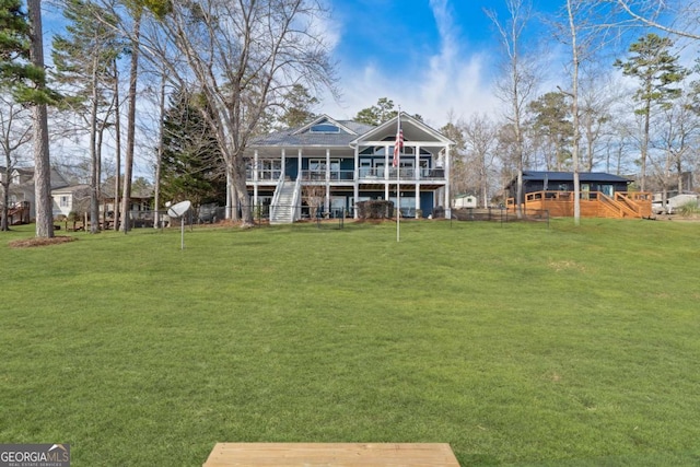 back of property featuring stairs, a lawn, fence, and a wooden deck