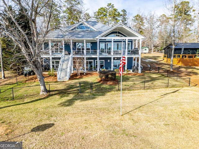 rear view of property with stairs, a yard, and fence